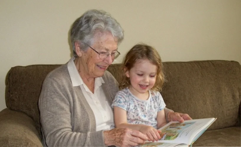 A grandmother reading a personalized storybook together with her granddaughter